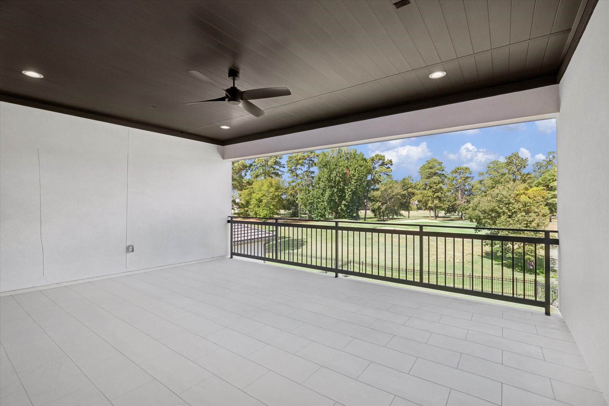 65 Shadow Creek Ridge Drive Spring, TX 77389 - Photo 31 of 41 Covered balcony with ceiling fan, recessed lighting, and sleek railing overlooking serene golf course greens.