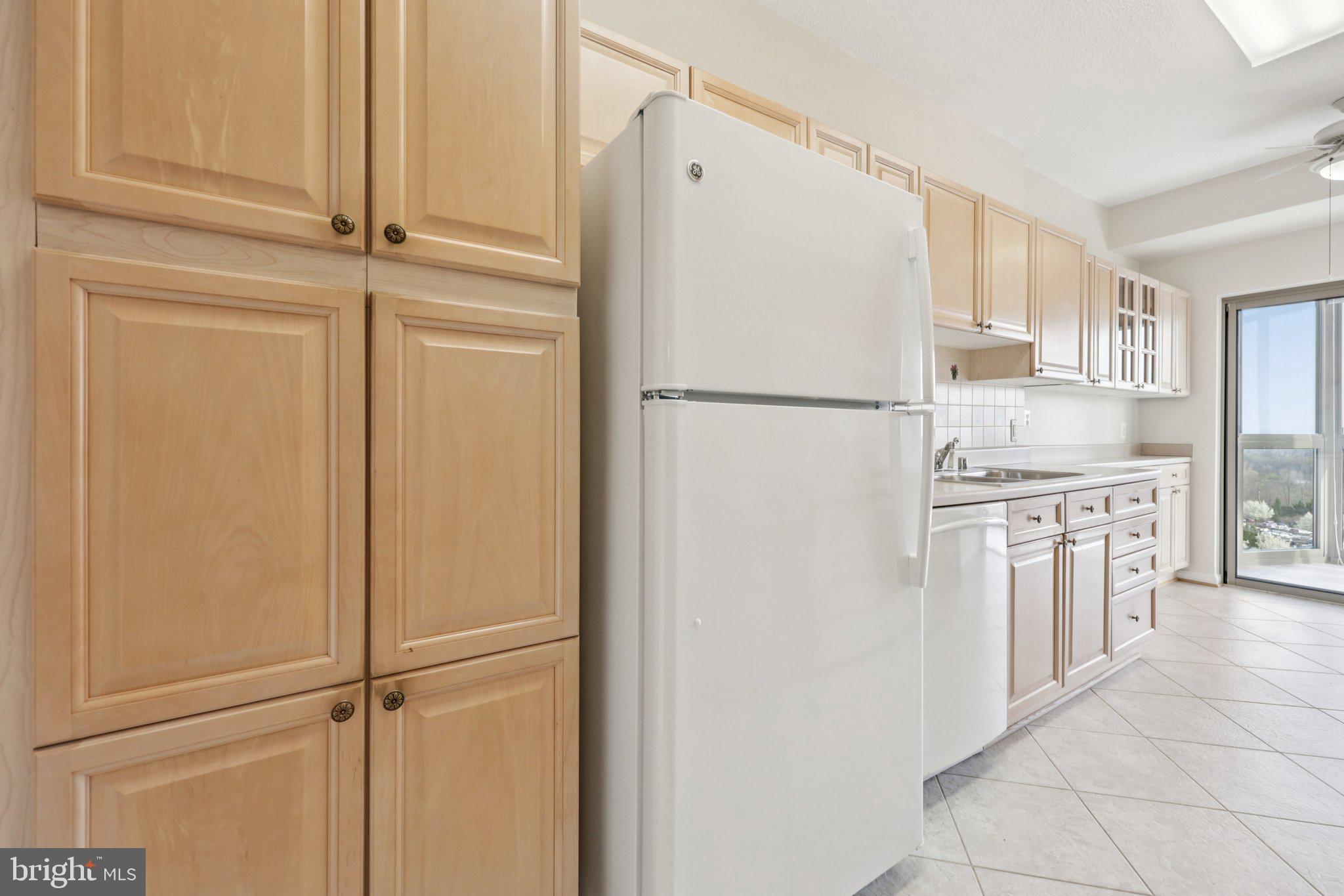 19375 Cypress Ridge Terrace, Unit 1111 Leesburg, VA 20176 - Photo 11 of 35 a white refrigerator freezer and a stove sitting inside of a kitchen