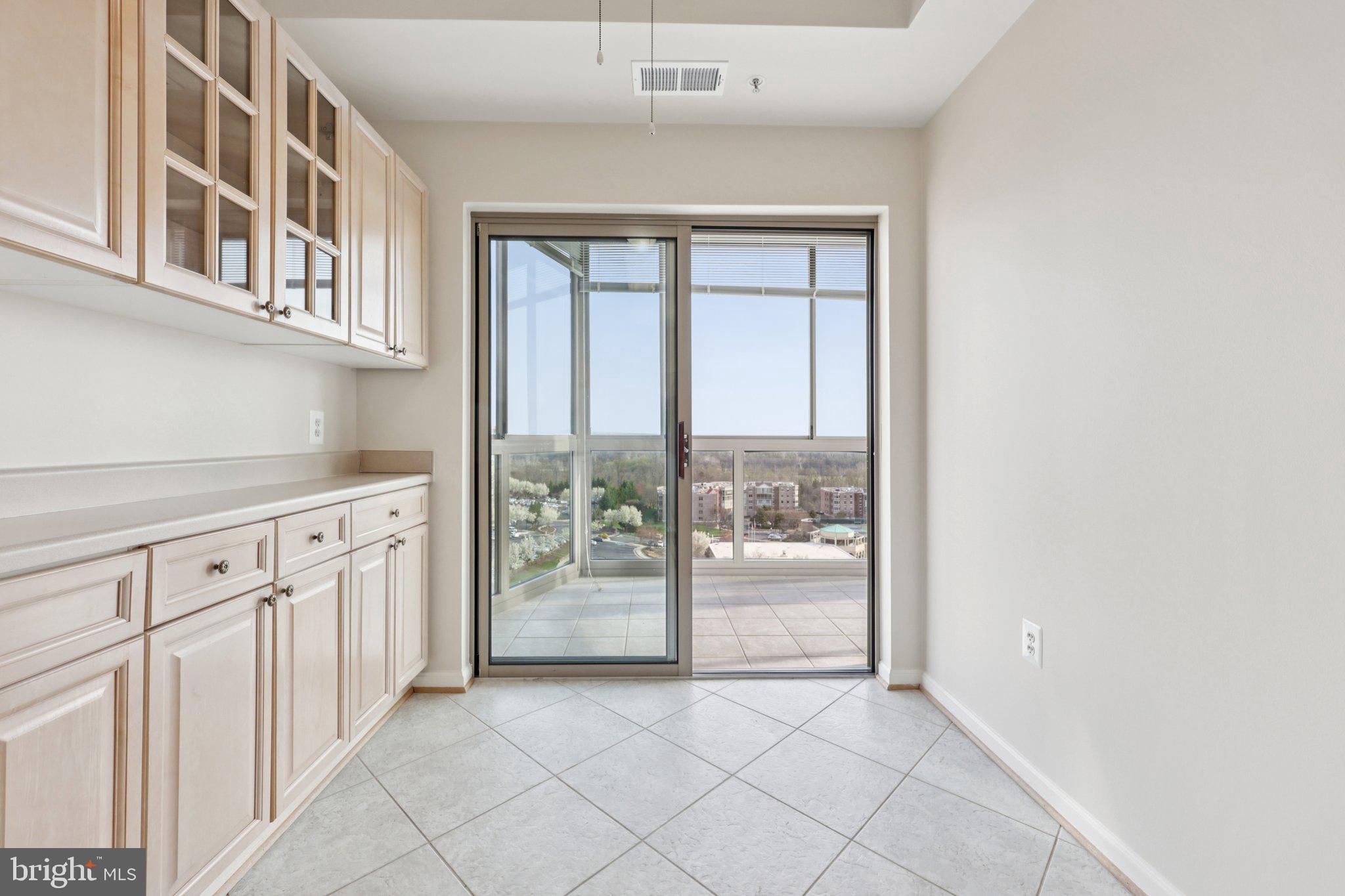 19375 Cypress Ridge Terrace, Unit 1111 Leesburg, VA 20176 - Photo 12 of 35 a view of a kitchen with white cabinets and a window