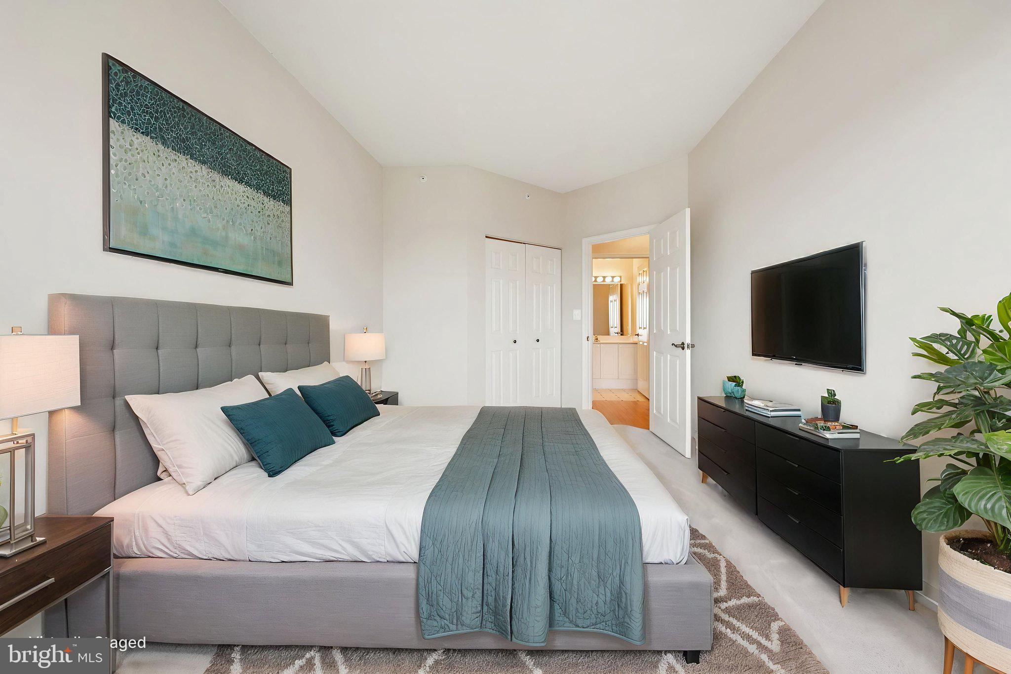 19375 Cypress Ridge Terrace, Unit 1111 Leesburg, VA 20176 - Photo 13 of 35 a bedroom with a bed and a flat screen tv