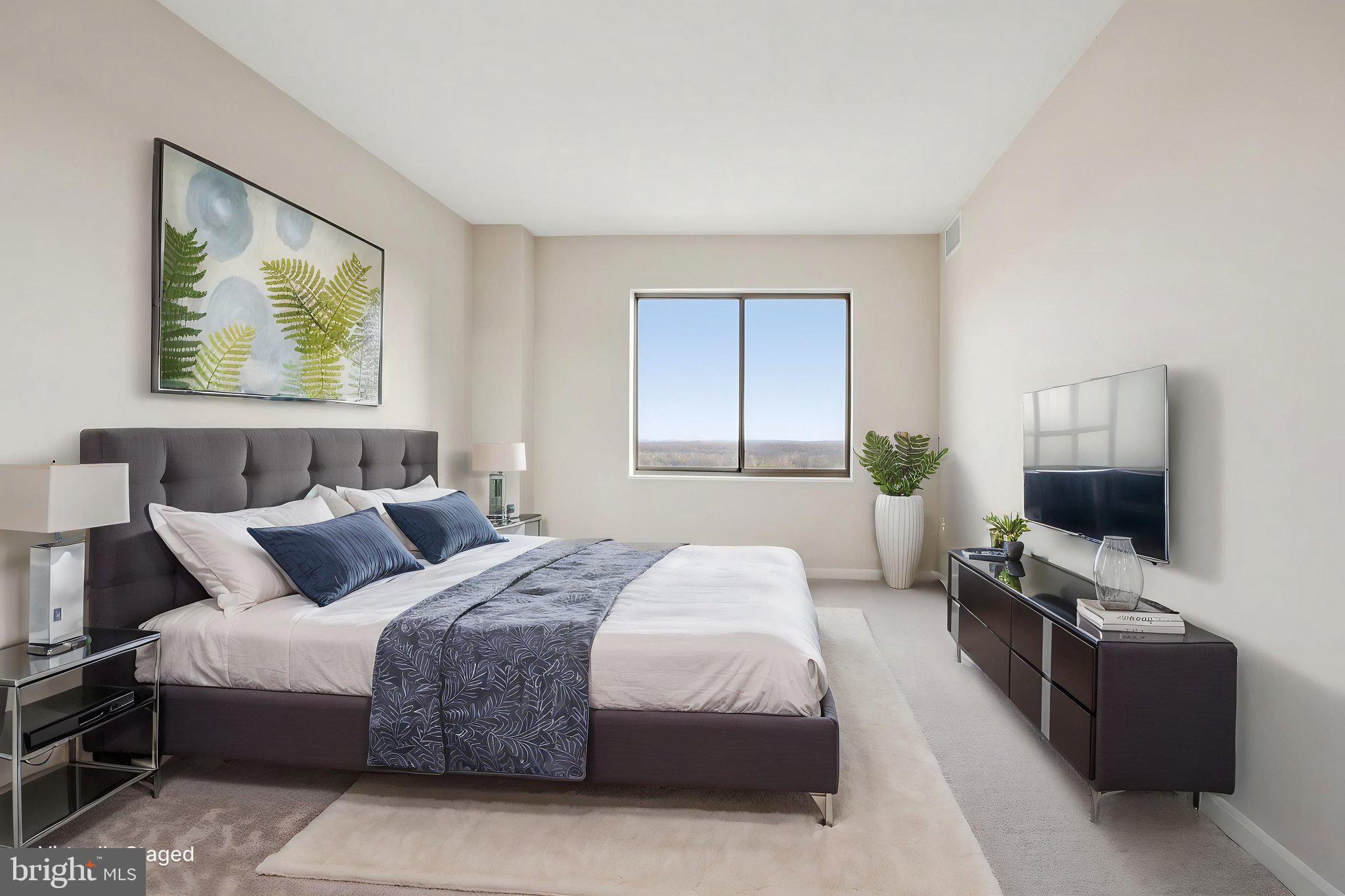 19375 Cypress Ridge Terrace, Unit 1111 Leesburg, VA 20176 - Photo 17 of 35 a bedroom with a bed and a flat screen tv