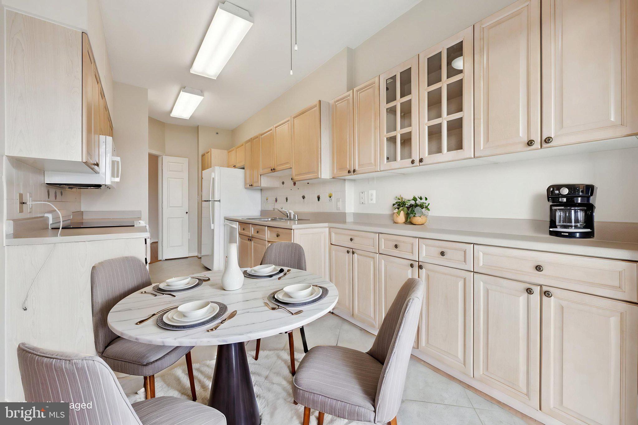 19375 Cypress Ridge Terrace, Unit 1111 Leesburg, VA 20176 - Photo 9 of 35 a kitchen with stainless steel appliances kitchen island granite countertop a sink a stove a table and chairs