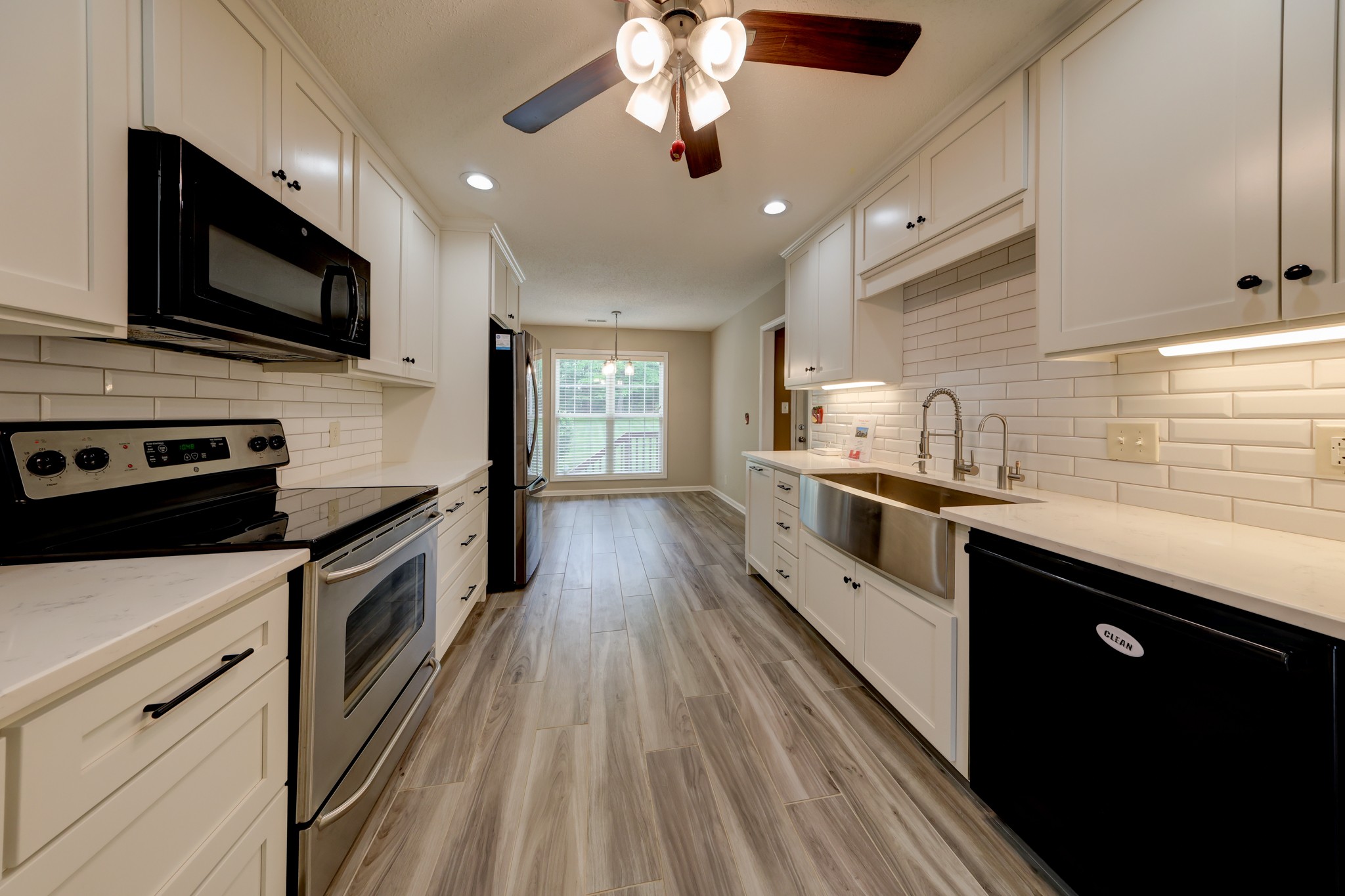4445 Taylor Hall Lane Adams, TN 37010 - Photo 19 of 65 a large kitchen with a stove top oven a sink a microwave and wooden floor