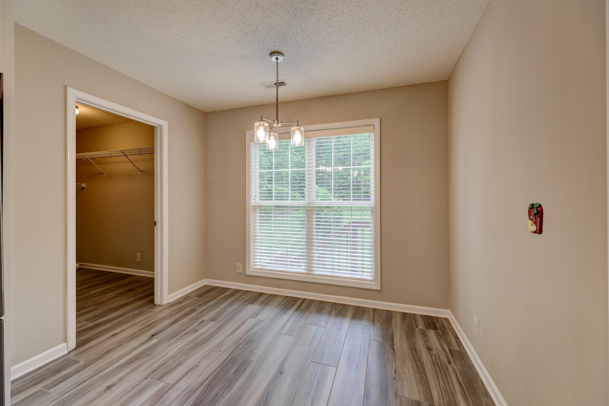 4445 Taylor Hall Lane Adams, TN 37010 - Photo 23 of 65 an empty room with wooden floor chandelier and windows