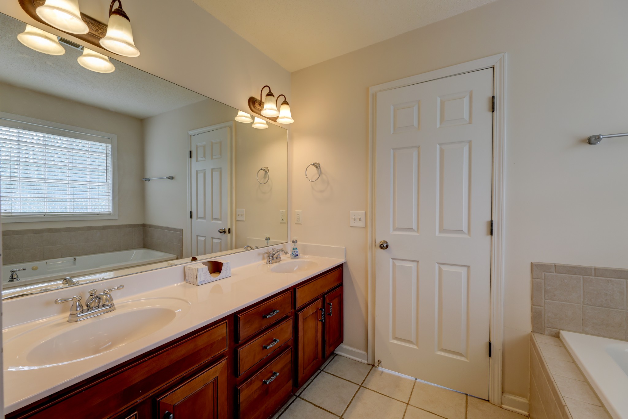 4445 Taylor Hall Lane Adams, TN 37010 - Photo 34 of 65 a spacious bathroom with a double vanity sink a mirror and a bathtub