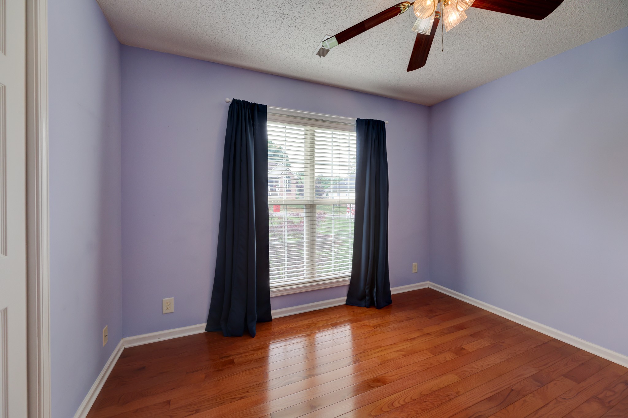 4445 Taylor Hall Lane Adams, TN 37010 - Photo 43 of 65 an empty room with wooden floor chandelier fan and windows