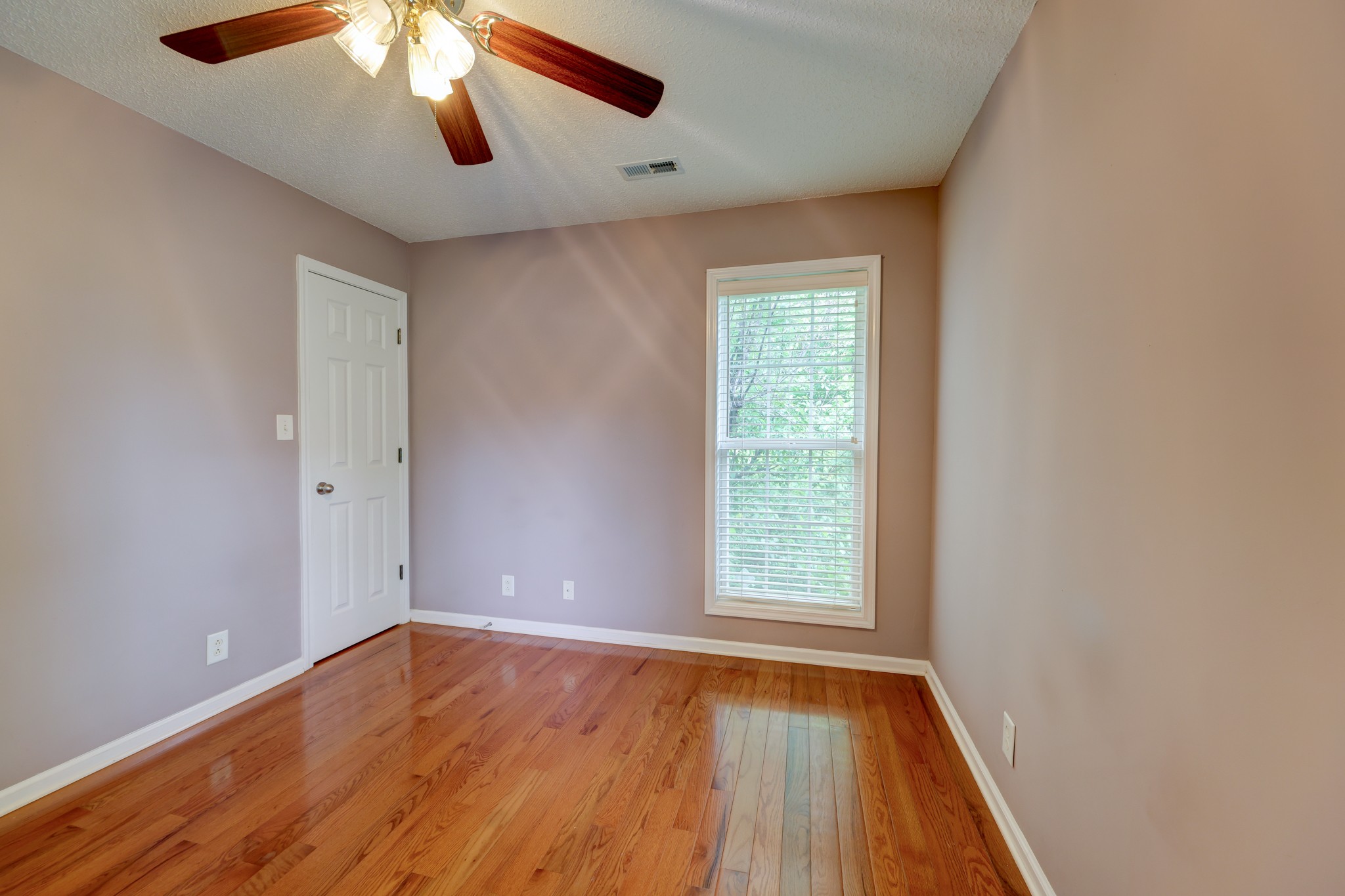 4445 Taylor Hall Lane Adams, TN 37010 - Photo 49 of 65 an empty room with wooden floor chandelier fan and windows