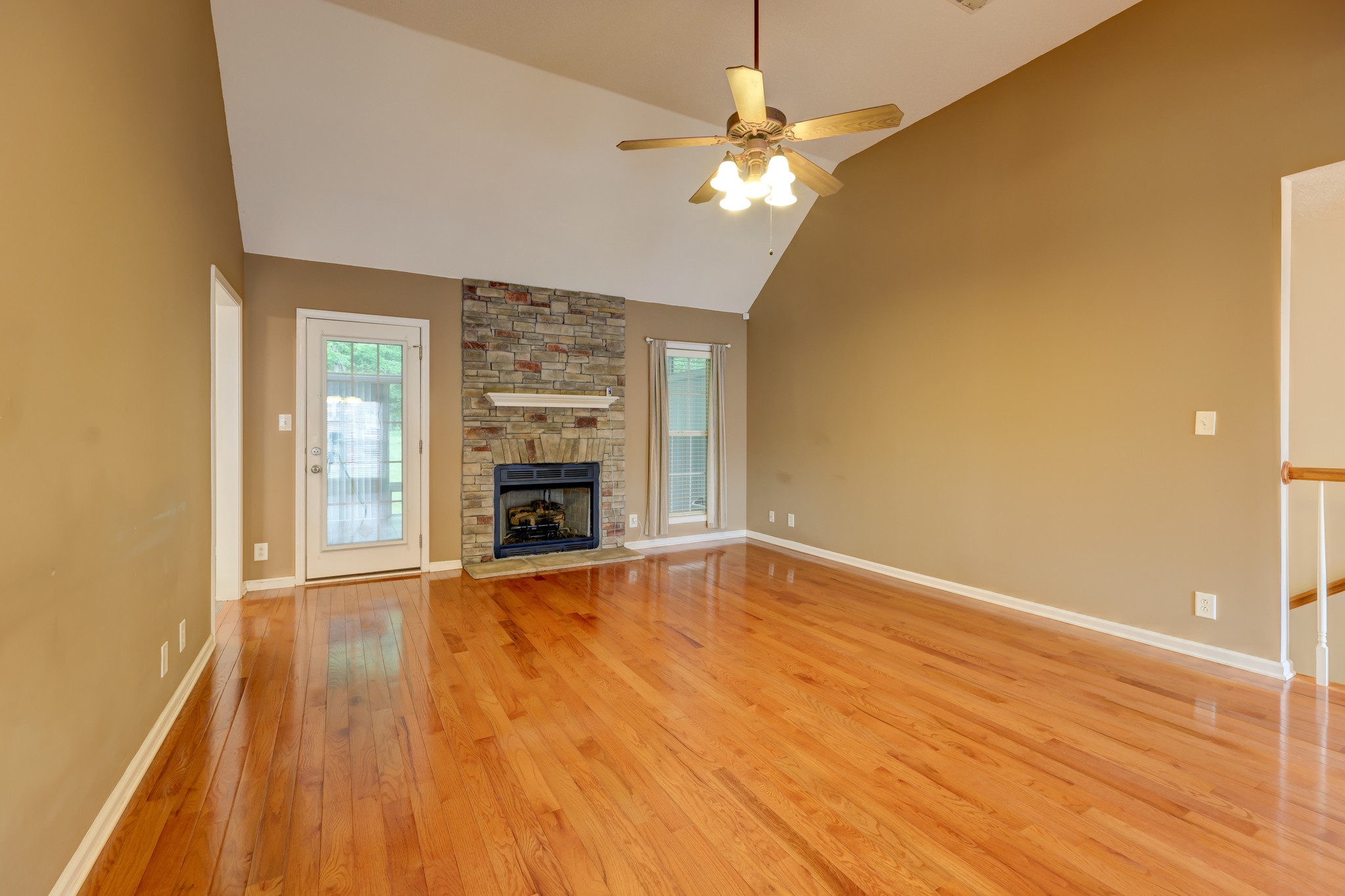 4445 Taylor Hall Lane Adams, TN 37010 - Photo 8 of 65 an empty room with wooden floor fireplace and chandelier