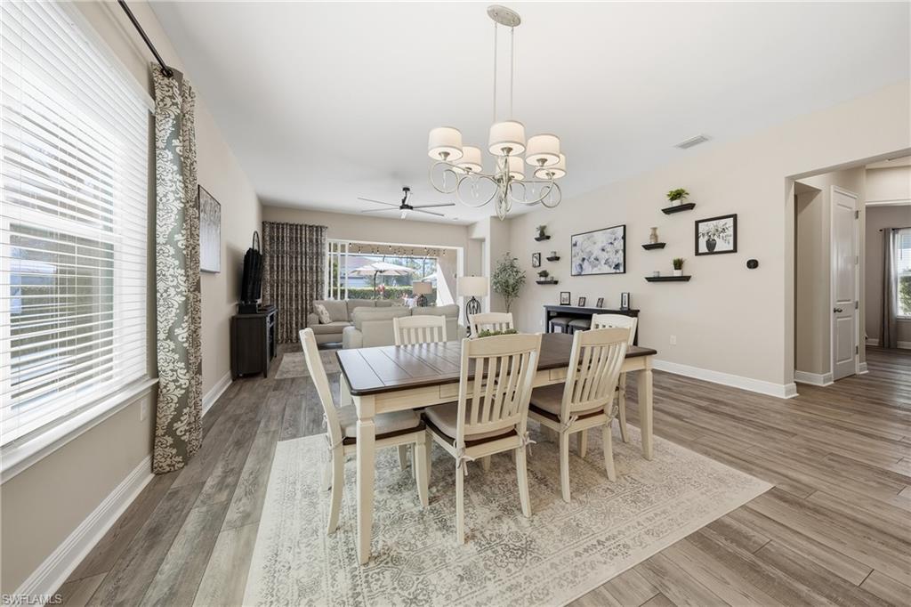 3344 Pilot Circle Naples, FL 34120 - Photo 14 of 50 a view of a dining room with furniture a chandelier and wooden floor