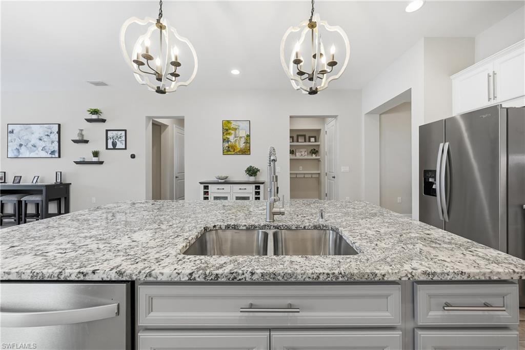 3344 Pilot Circle Naples, FL 34120 - Photo 8 of 50 a view of a kitchen counter space a sink and stainless steel appliances