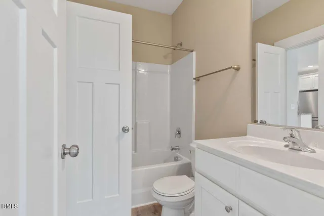 a bathroom with a granite countertop sink a toilet and shower