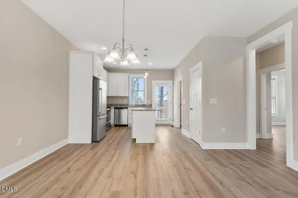 a view of a kitchen with a sink dishwasher a refrigerator and wooden floor