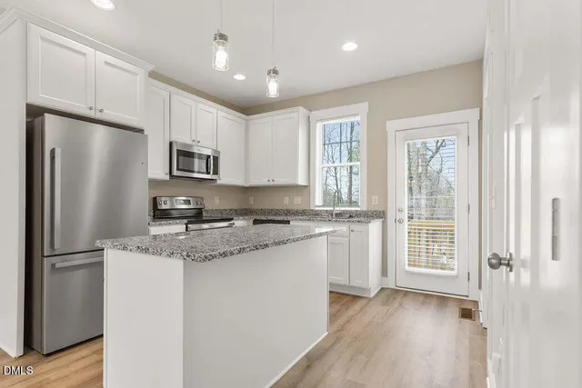 a kitchen with a refrigerator a sink and cabinets