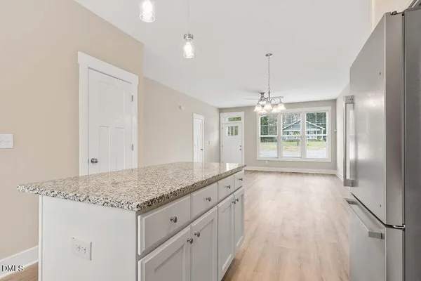 a kitchen with granite countertop a stove a sink and a refrigerator