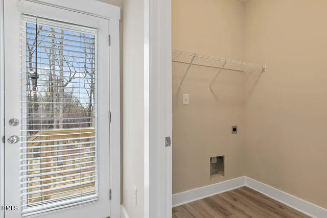 a view of a small space with wooden floor and a window