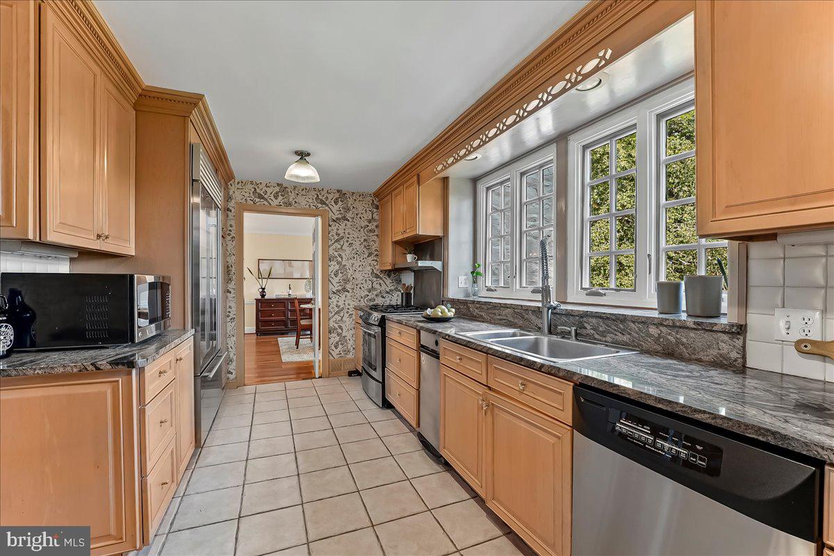 716 Old Gulph Road Bryn Mawr, PA 19010 - Photo 17 of 58 a kitchen with stainless steel appliances granite countertop a sink stove and cabinets