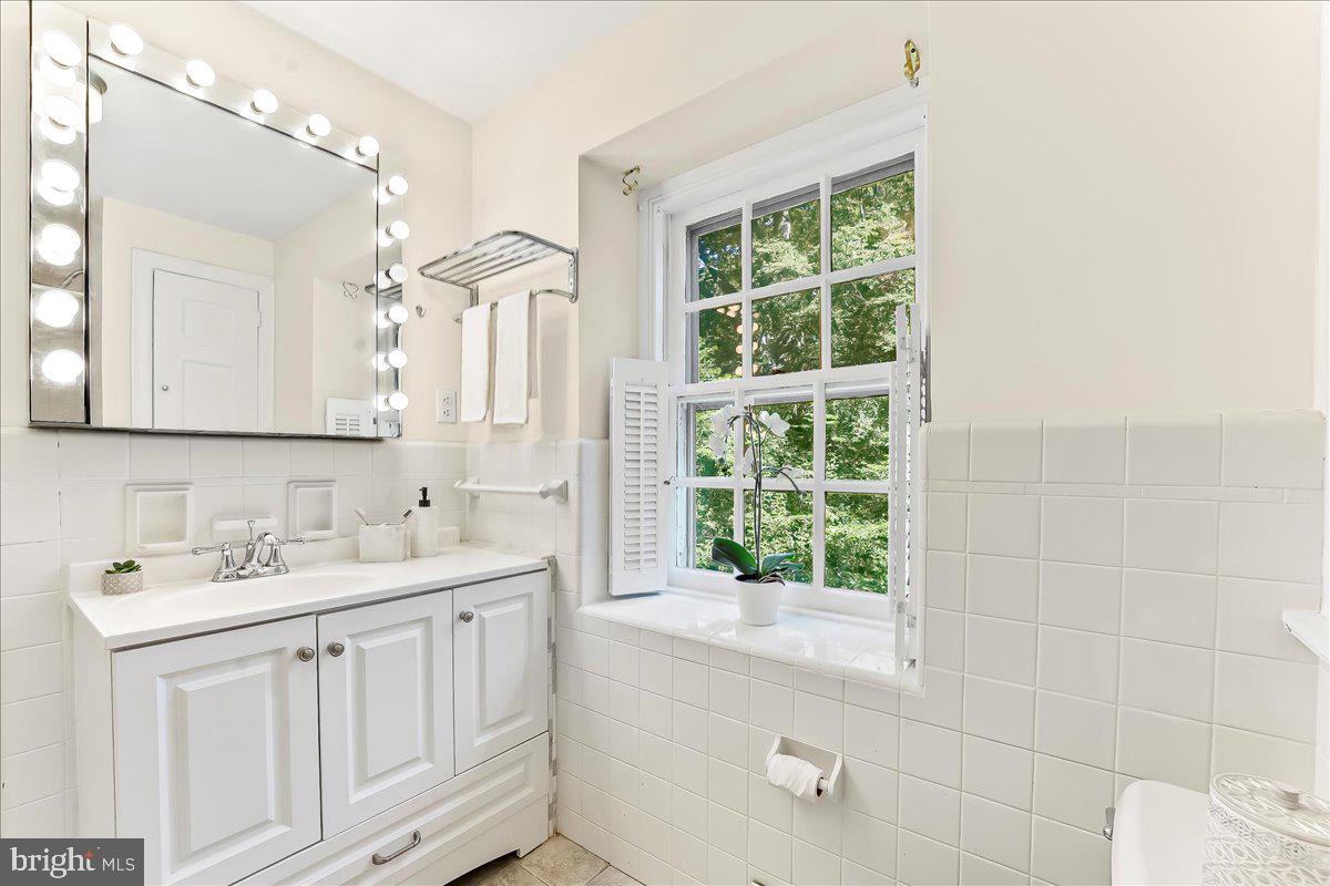 716 Old Gulph Road Bryn Mawr, PA 19010 - Photo 28 of 58 a bathroom with a double vanity sink a mirror and a bathtub