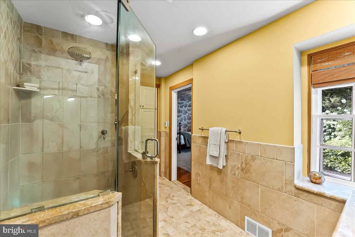 716 Old Gulph Road Bryn Mawr, PA 19010 - Photo 29 of 58 a bathroom with a glass shower door and a sink