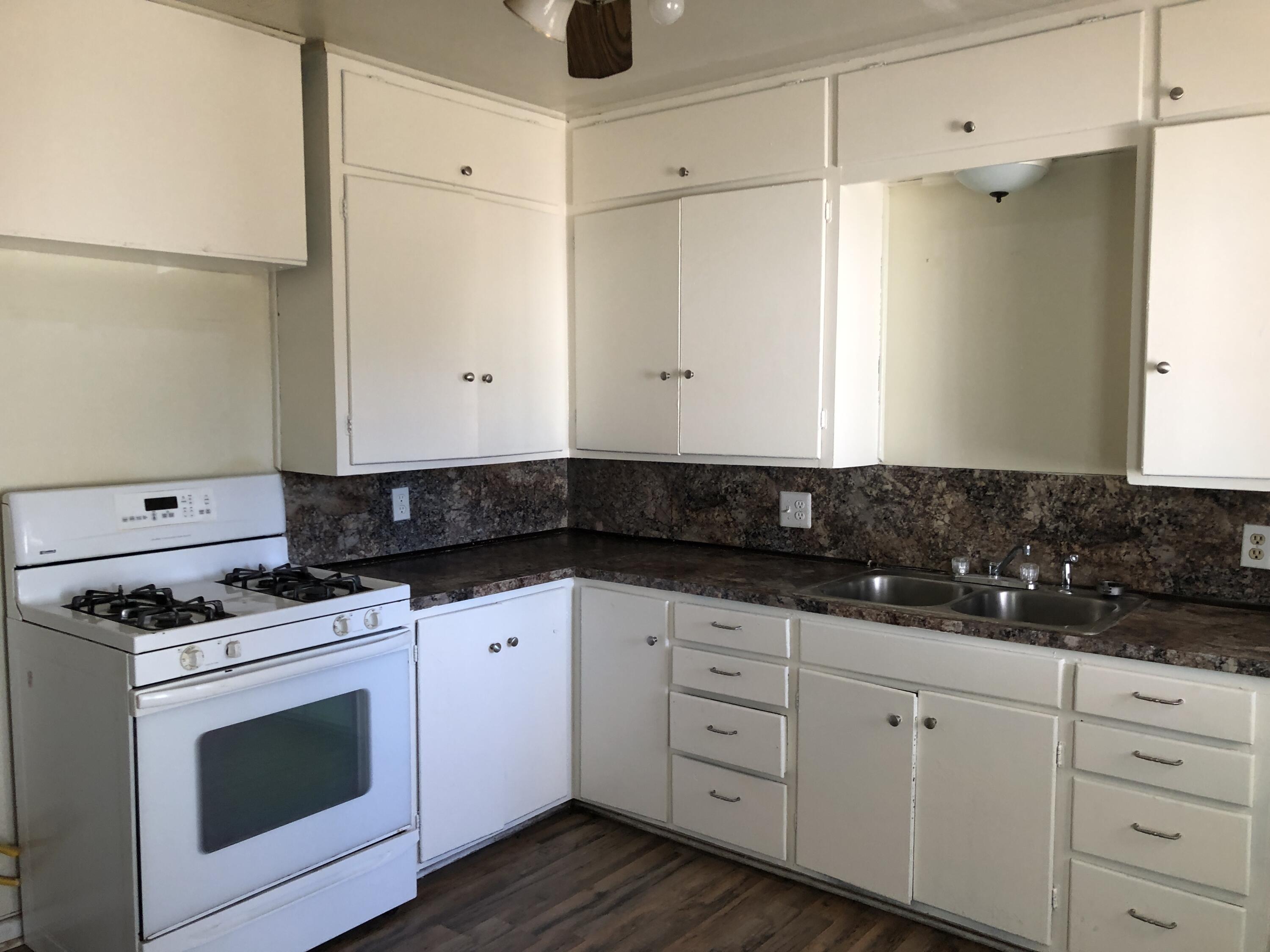 5107 40th Street Lubbock, TX 79414 - Photo 6 of 10 a kitchen with granite countertop white cabinets and white appliances