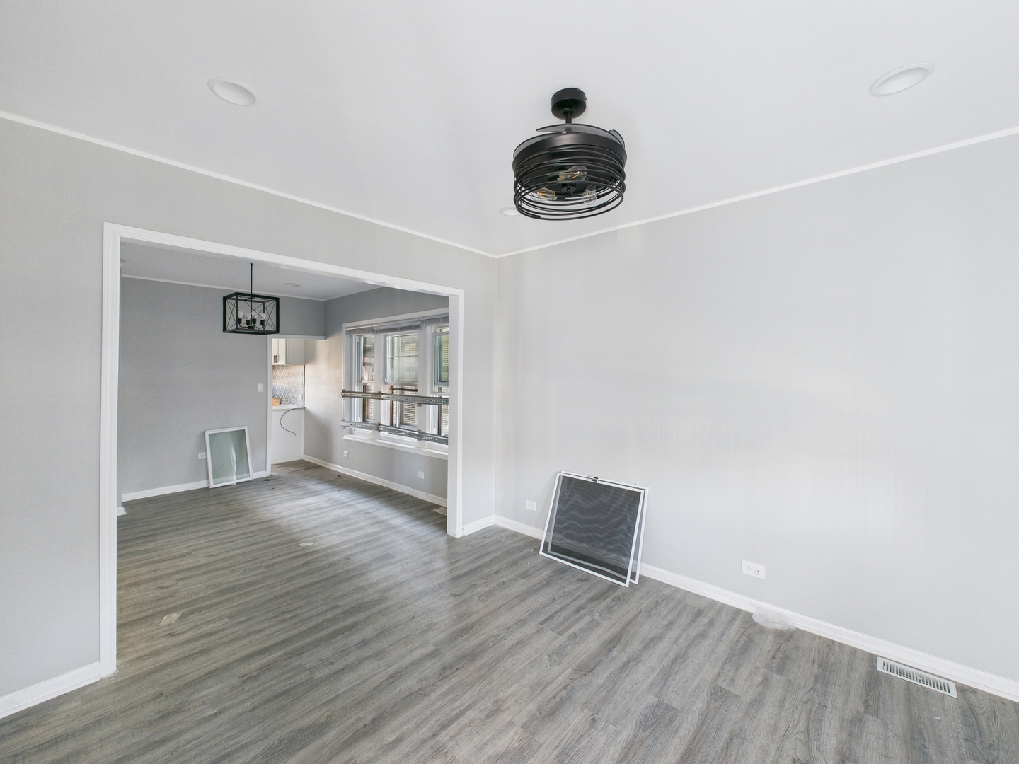 7425 South Perry Avenue Chicago, IL 60621 - Photo 4 of 16 a view of an empty room with a window and wooden floor