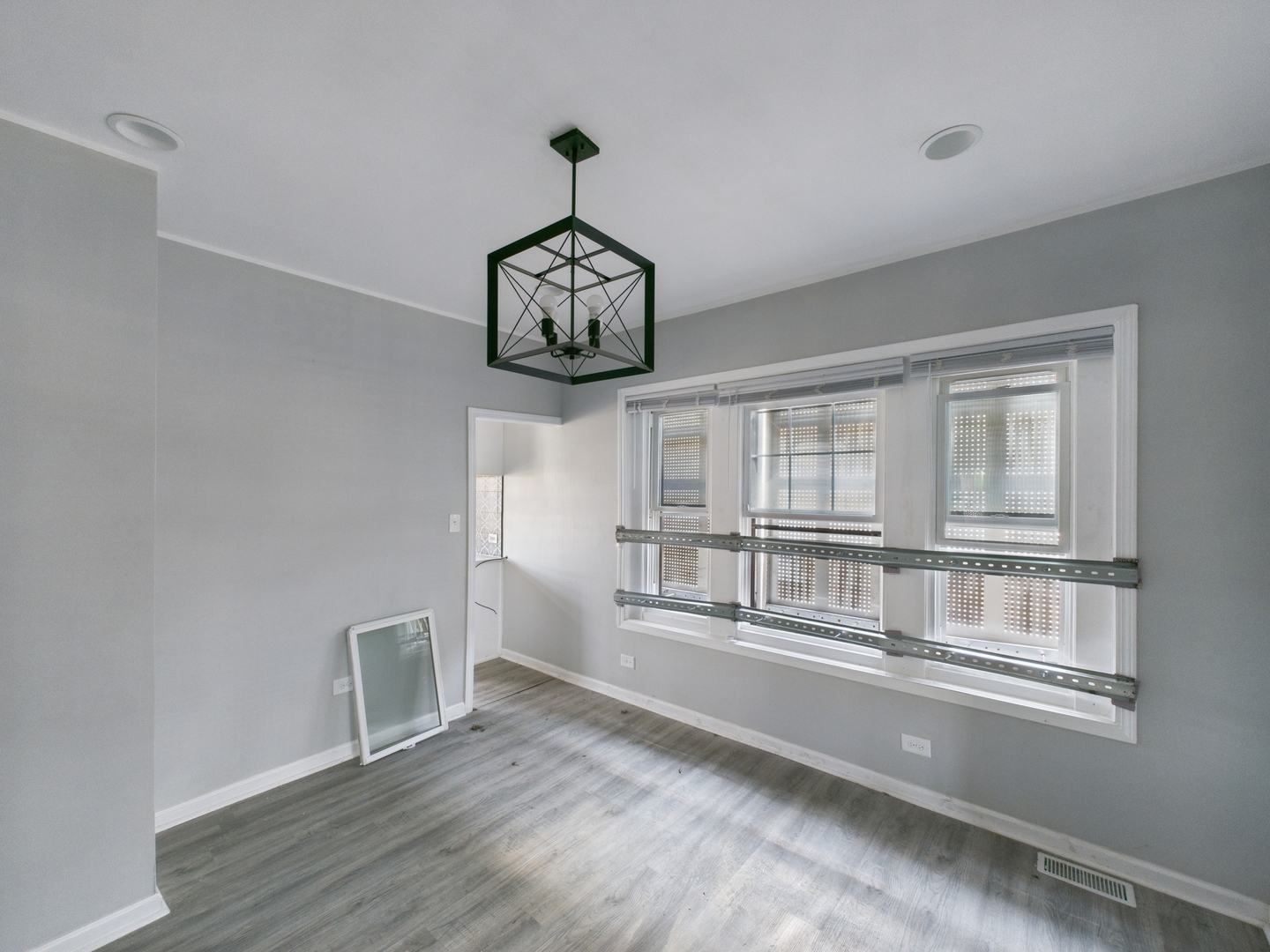 7425 South Perry Avenue Chicago, IL 60621 - Photo 5 of 16 a view of an empty room with wooden floor and a window