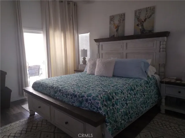 a bedroom with a bed wooden floor and window