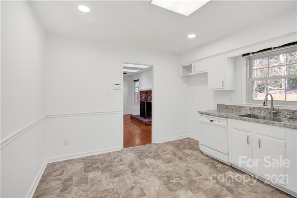 7243 Fox Hunt Road Charlotte, NC 28212 - Photo 23 of 34 a kitchen with granite countertop a sink and a stove top oven
