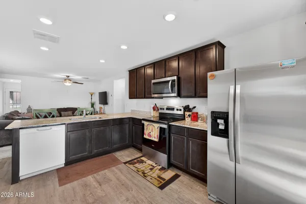 a kitchen with granite countertop a sink cabinets and wooden floor