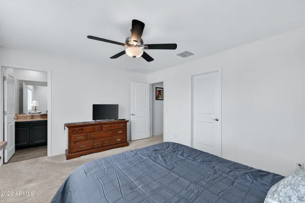 a bedroom with a bed and dresser with mirror