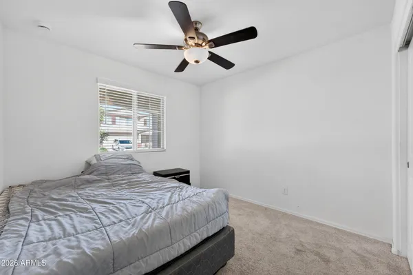 a bedroom with a bed and a ceiling fan
