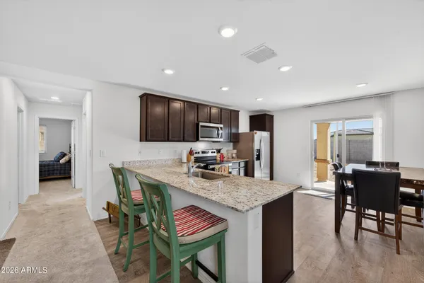 a kitchen with stainless steel appliances granite countertop a refrigerator and a stove top oven