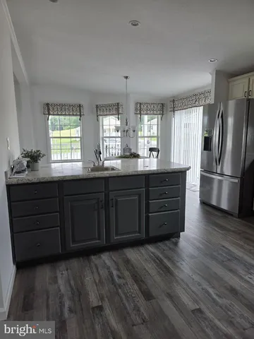 a kitchen with stainless steel appliances granite countertop a refrigerator a sink dishwasher a stove and a refrigerator