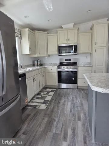 a kitchen with granite countertop a refrigerator stove top oven and sink