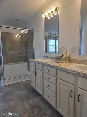 a bathroom with a granite countertop sink mirror and bathtub