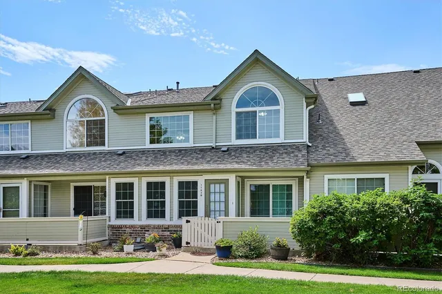 a front view of a house with yard and green space