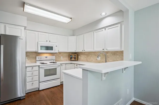 a kitchen with stainless steel appliances white cabinets and a refrigerator