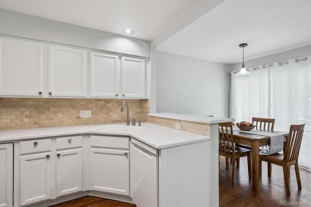 a kitchen with a table chairs and white cabinets