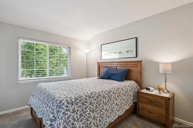 a bedroom with a bed and painting on the wall