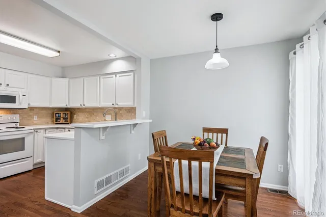 a view of a dining room with furniture wooden floor and a chandelier