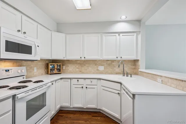a kitchen with white cabinets appliances and sink