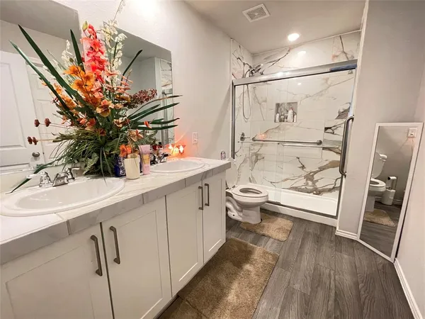 a bathroom with a sink a toilet and shower