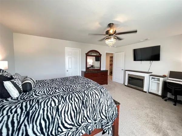 a spacious bedroom with a bed and a flat screen tv
