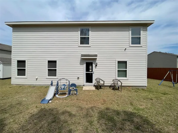 a backyard of a house with table and chairs