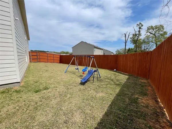 a view of an house with backyard and wooden fence