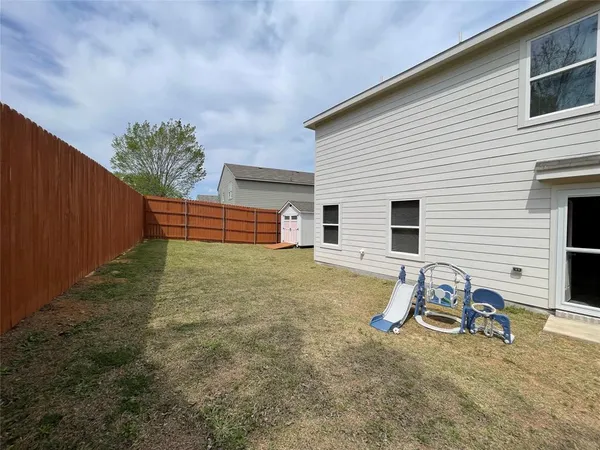 a backyard of a house with table and chairs