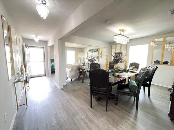 a view of a a dining room with furniture window and wooden floor