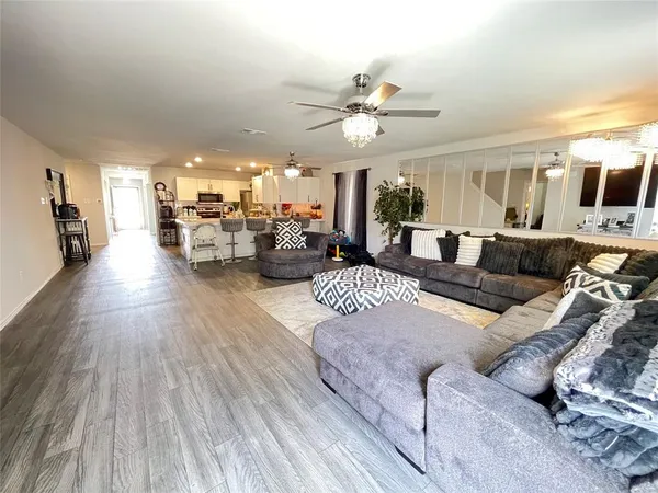 a living room with furniture and a wooden floor