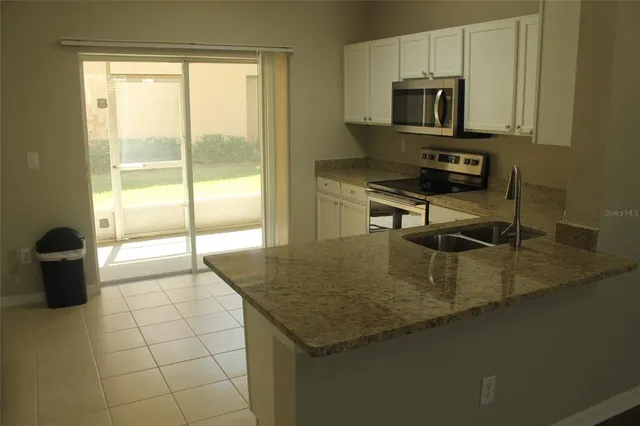 a kitchen with a sink a counter top space cabinets and stainless steel appliances
