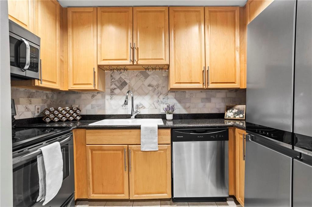 195 14th Street Northeast, Unit 604 Atlanta, GA 30309 - Photo 11 of 25 a kitchen with stainless steel appliances granite countertop a stove a sink and a microwave