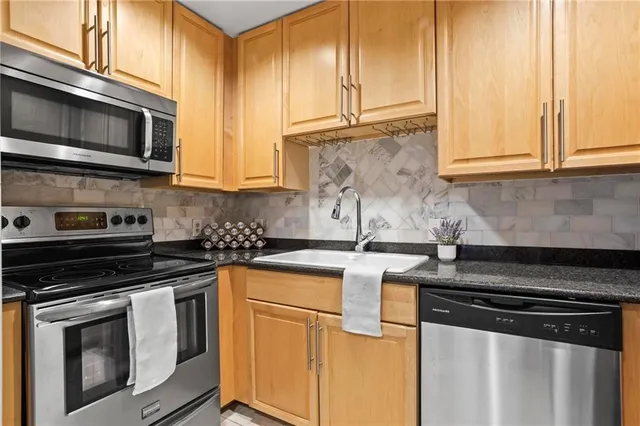 a kitchen with stainless steel appliances granite countertop a stove and a microwave